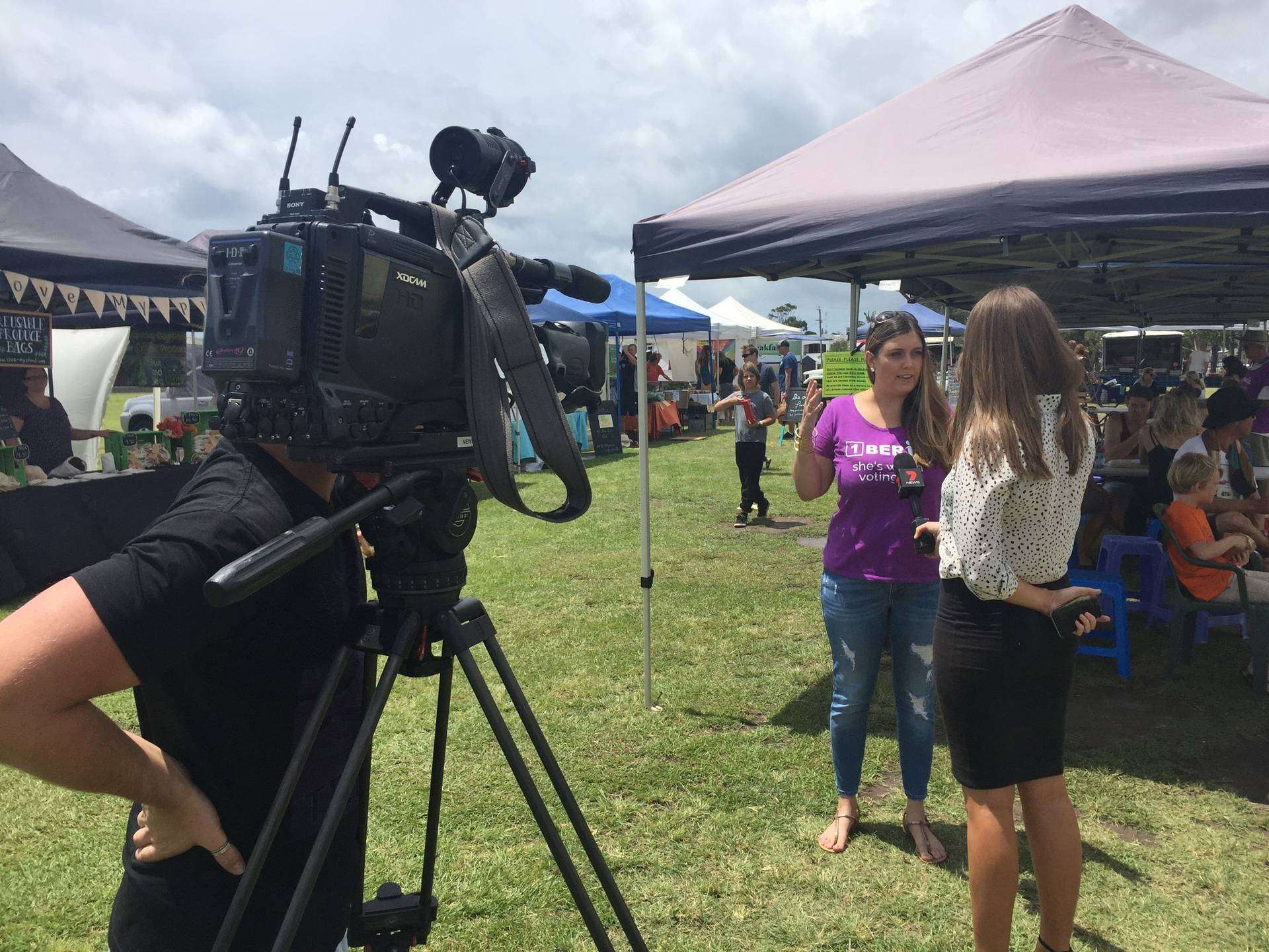 Candidate interviewed by TV news at a local market